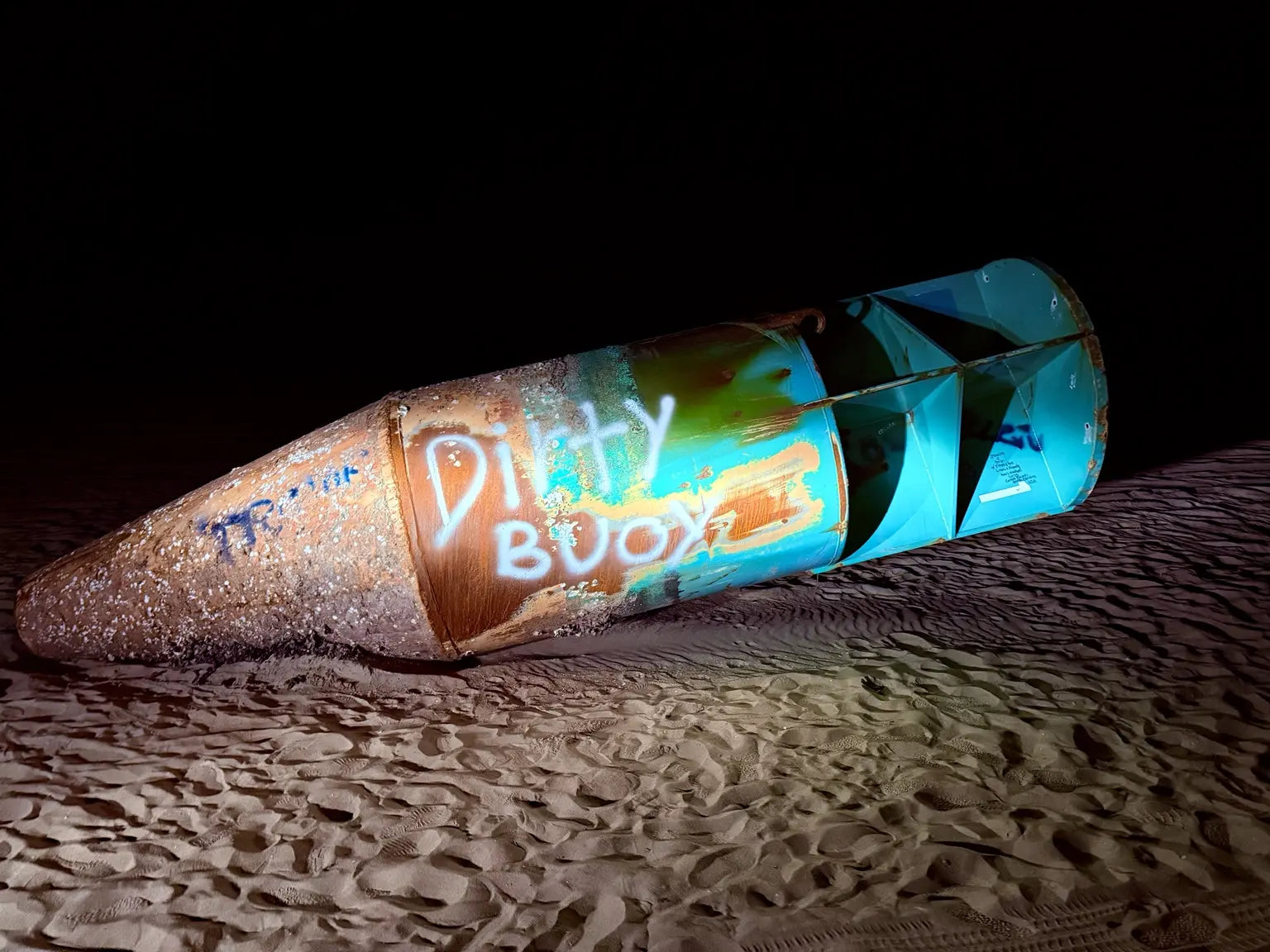 Weathered Dirty Buoy on the beach at night