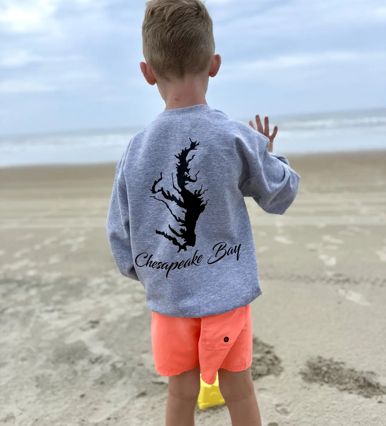 Child wearing a Chesapeake Bay sweatshirt at the beach